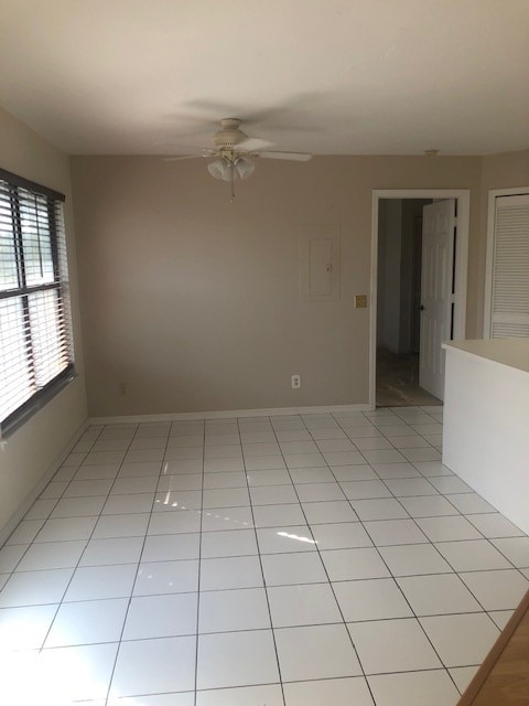 tiled spare room with ceiling fan