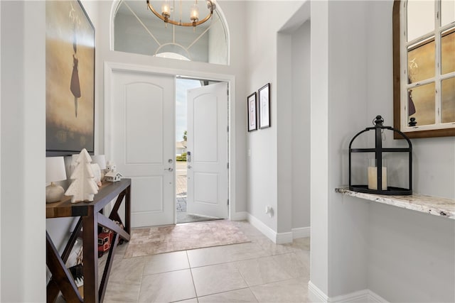 entrance foyer featuring an inviting chandelier, light tile patterned floors, and plenty of natural light