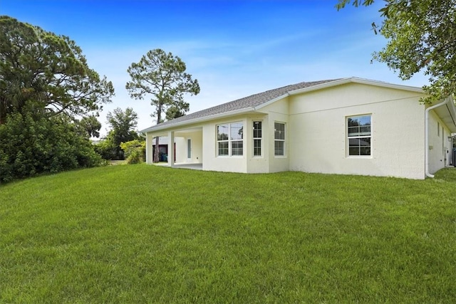 614 Stevenson Ave, Sebastian, FL 32958 - rear view of house with stucco siding and a lawn