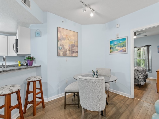 dining room featuring ceiling fan, dark hardwood / wood-style flooring, a textured ceiling, and sink