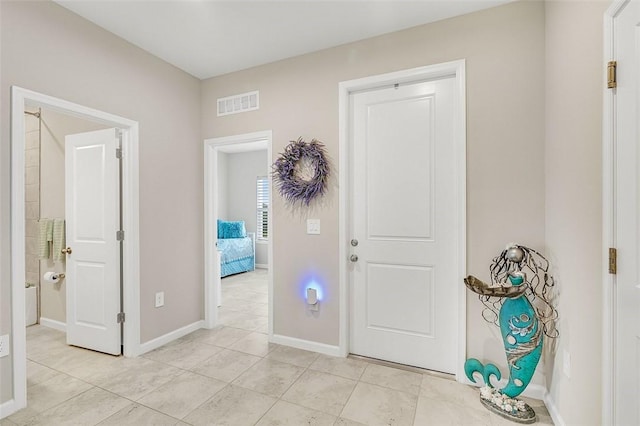 entryway with visible vents, baseboards, and light tile patterned flooring