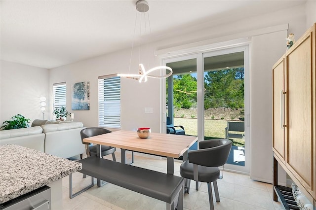 dining area featuring light tile patterned flooring and a chandelier