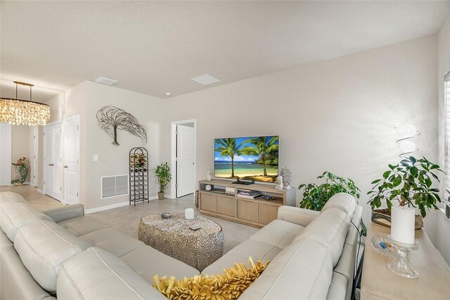 living room featuring baseboards, visible vents, and a chandelier