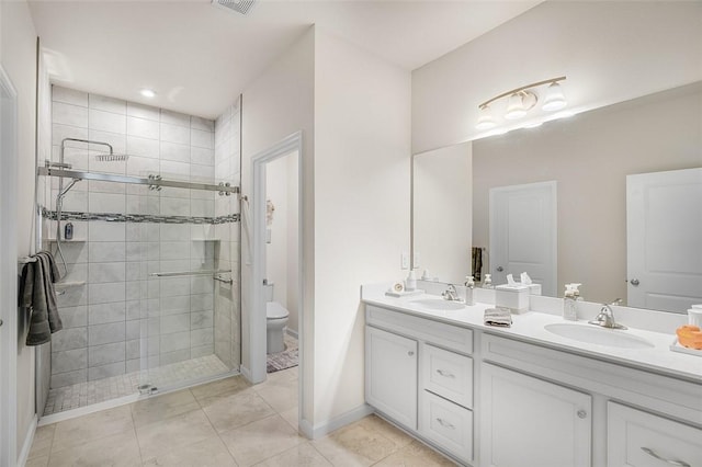 full bathroom with a sink, toilet, a stall shower, and double vanity