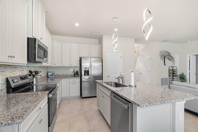 kitchen featuring visible vents, stainless steel appliances, decorative backsplash, and a sink