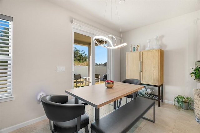 dining room featuring light tile patterned floors, baseboards, and an inviting chandelier