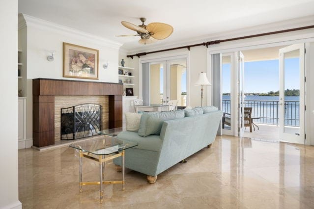 living area featuring marble finish floor, ornamental molding, built in features, a fireplace, and ceiling fan