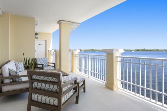 balcony featuring an outdoor living space and a water view