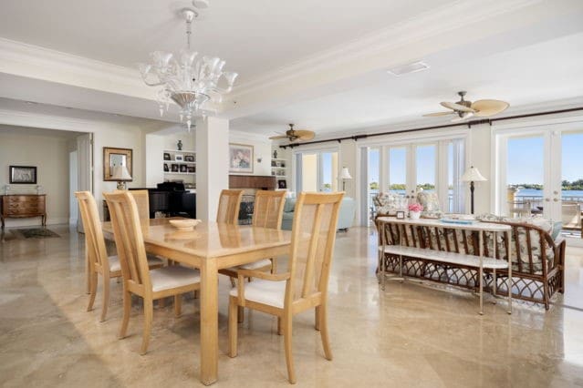 dining area featuring a tray ceiling, ornamental molding, french doors, and ceiling fan with notable chandelier