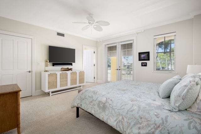 carpeted bedroom featuring visible vents, a ceiling fan, access to outside, crown molding, and baseboards