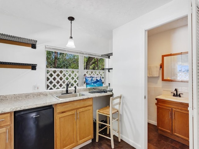 kitchen with pendant lighting, sink, tile walls, and black dishwasher