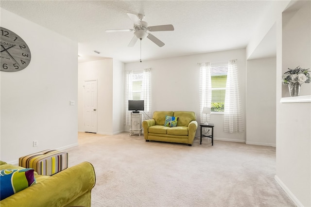 carpeted living room with a textured ceiling and ceiling fan