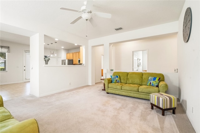 carpeted living room featuring ceiling fan