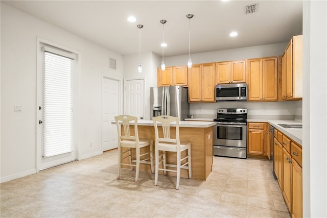 kitchen featuring pendant lighting, stainless steel appliances, a healthy amount of sunlight, and a center island