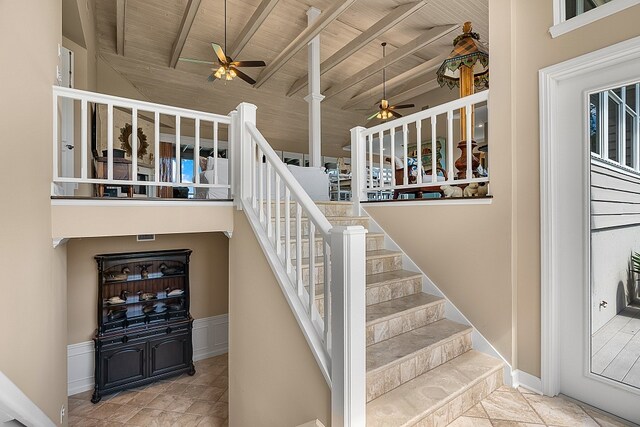 stairway featuring ceiling fan, beamed ceiling, wood ceiling, and high vaulted ceiling