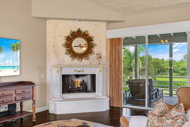 living room with hardwood / wood-style floors, a wealth of natural light, lofted ceiling, and a high end fireplace