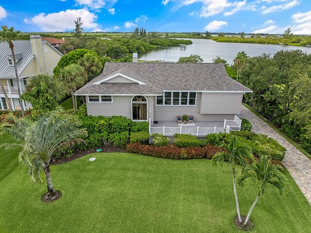 view of front facade featuring a front lawn and a water view