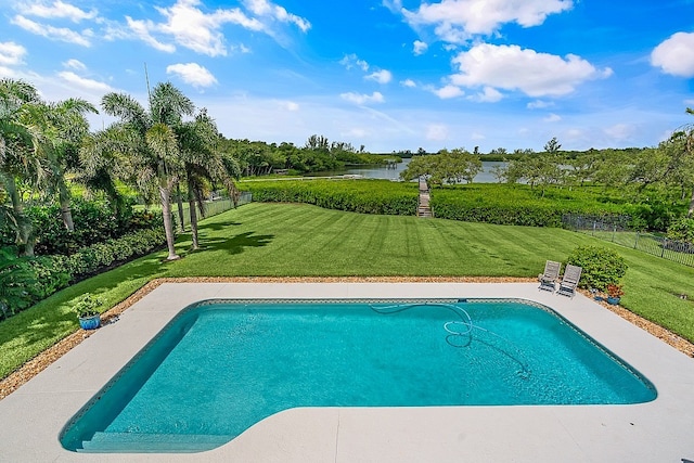 view of swimming pool featuring a yard and a water view