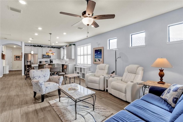 living room with ceiling fan and light hardwood / wood-style floors