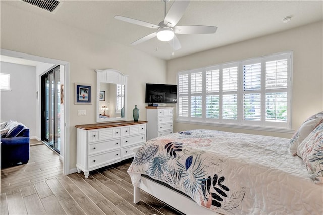 bedroom with multiple windows, access to outside, and ceiling fan