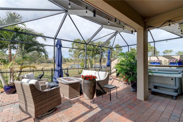 view of patio with a hot tub, an outdoor living space with a fire pit, and glass enclosure