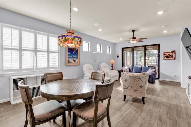 dining space with light hardwood / wood-style flooring and ceiling fan