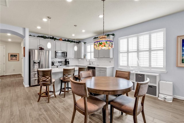 dining area with sink and light wood-type flooring