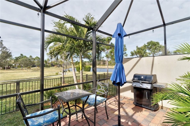 view of patio featuring a grill and glass enclosure