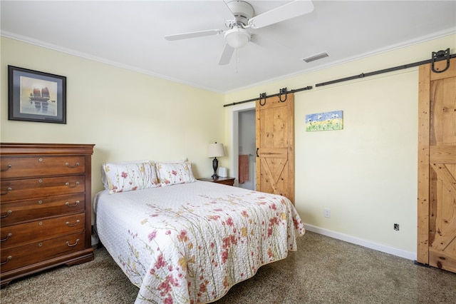 bedroom with a barn door, dark carpet, ceiling fan, and crown molding