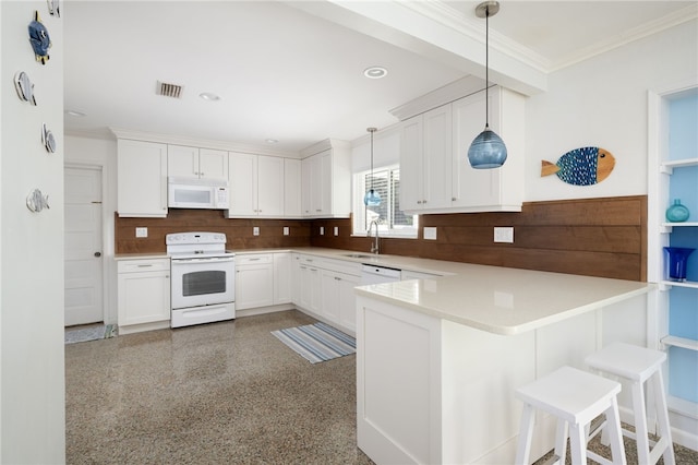 kitchen featuring a breakfast bar, white appliances, kitchen peninsula, decorative light fixtures, and white cabinetry