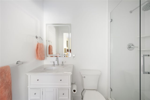 bathroom with vanity, a shower with shower door, and toilet