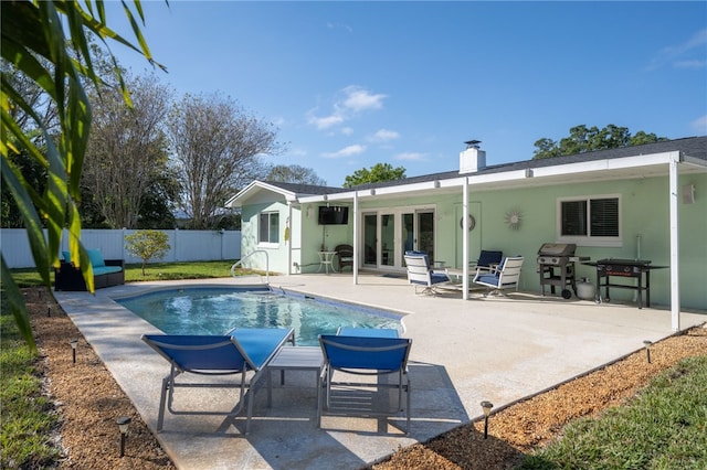 back of property featuring french doors, a fenced in pool, and a patio area