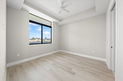 225 Strand Dr Unit 204, Melbourne Beach, FL 32951 - empty room featuring light wood finished floors, a raised ceiling, and a ceiling fan
