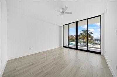 225 Strand Dr Unit 204, Melbourne Beach, FL 32951 - empty room featuring light wood-style floors, a wall of windows, and ceiling fan