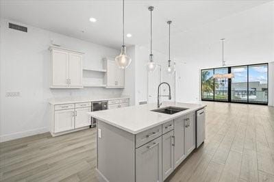 225 Strand Dr Unit 204, Melbourne Beach, FL 32951 - kitchen featuring light wood-style floors, open shelves, dishwasher, white cabinetry, and light countertops