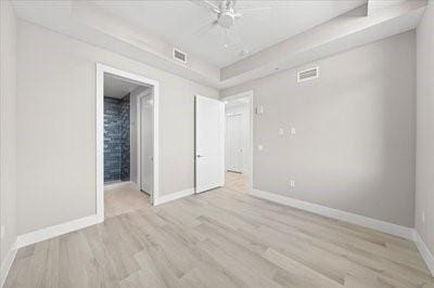 225 Strand Dr Unit 204, Melbourne Beach, FL 32951 - unfurnished bedroom with light wood-type flooring, ensuite bath, and a ceiling fan