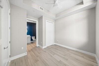 225 Strand Dr Unit 204, Melbourne Beach, FL 32951 - unfurnished bedroom featuring wood finished floors, a raised ceiling, a closet, and a ceiling fan