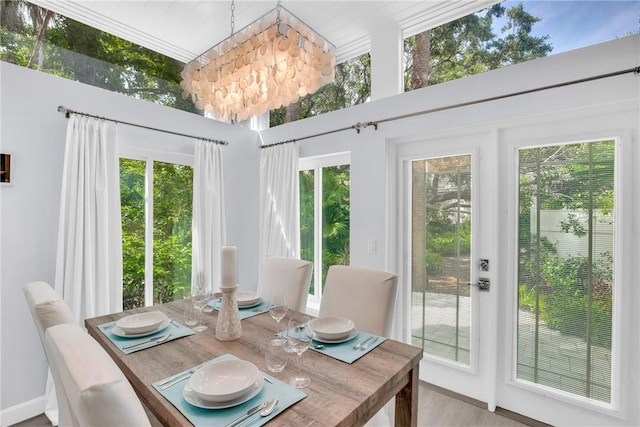 dining space featuring a chandelier, wood finished floors, and plenty of natural light