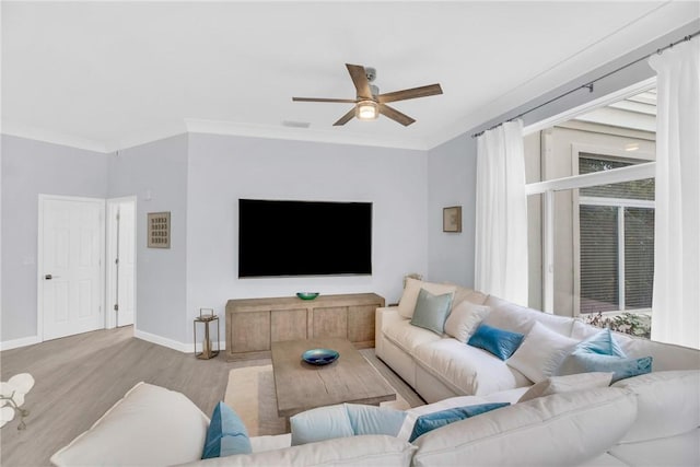 living room featuring wood finished floors, ceiling fan, ornamental molding, and baseboards