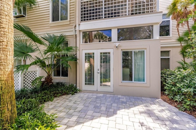 view of exterior entry featuring french doors and stucco siding