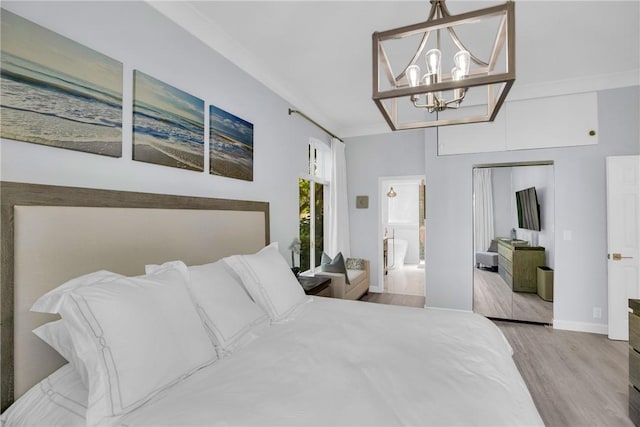 bedroom featuring baseboards, wood finished floors, and an inviting chandelier