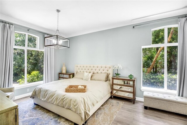 1255 Winding Oaks Cir E Unit 604, Vero Beach, FL 32963 - bedroom featuring a chandelier, multiple windows, and wood finished floors