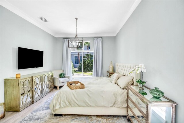 1255 Winding Oaks Cir E Unit 604, Vero Beach, FL 32963 - bedroom featuring ornamental molding, wood finished floors, and a chandelier