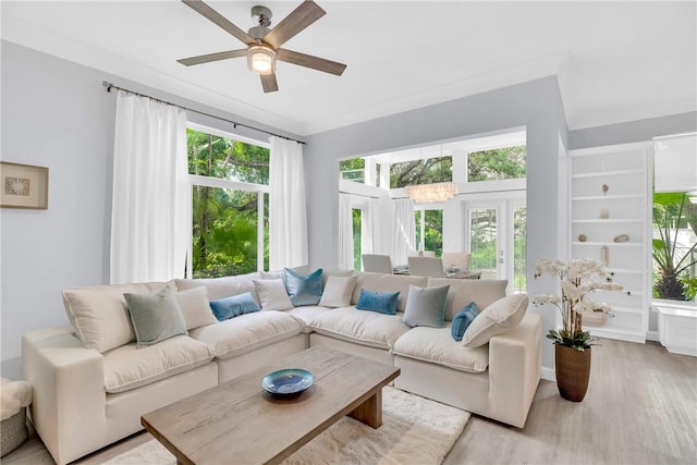 living area with a wealth of natural light, a ceiling fan, and light wood finished floors