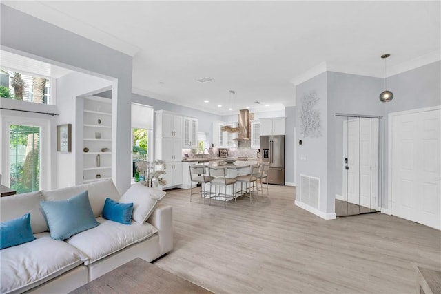living area with crown molding and visible vents