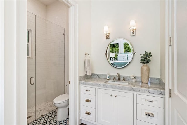 bathroom with vanity, toilet, and a shower with door