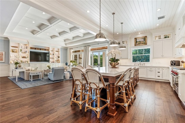 dining room with sink, dark hardwood / wood-style floors, coffered ceiling, ornamental molding, and beamed ceiling