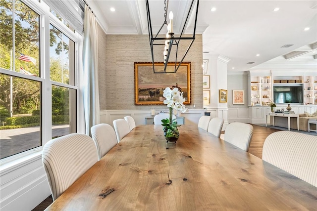 dining area with hardwood / wood-style floors and crown molding