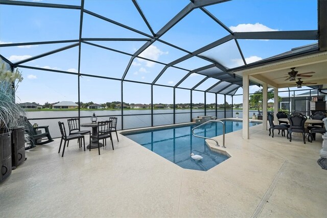 view of swimming pool featuring a patio area, a water view, a lanai, and ceiling fan