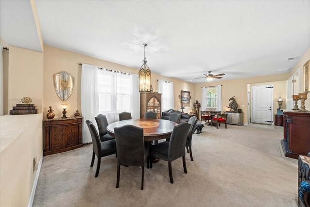 dining area featuring light carpet and ceiling fan